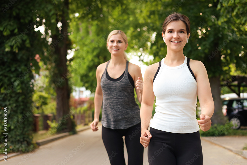 Fototapeta premium Women running on city street in morning