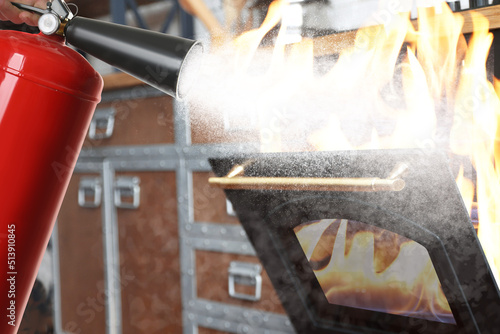Putting out burning oven with fire extinguisher in kitchen