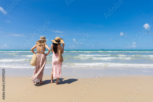 back view women couple standing on the beach during summer vacation