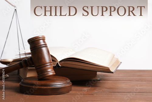 Judge's gavel, scales of justice and books on wooden table. Child support concept