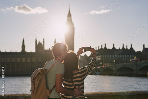 Photography Rearview shot of a couple taking photos of Big Ben with a smartphone while explo