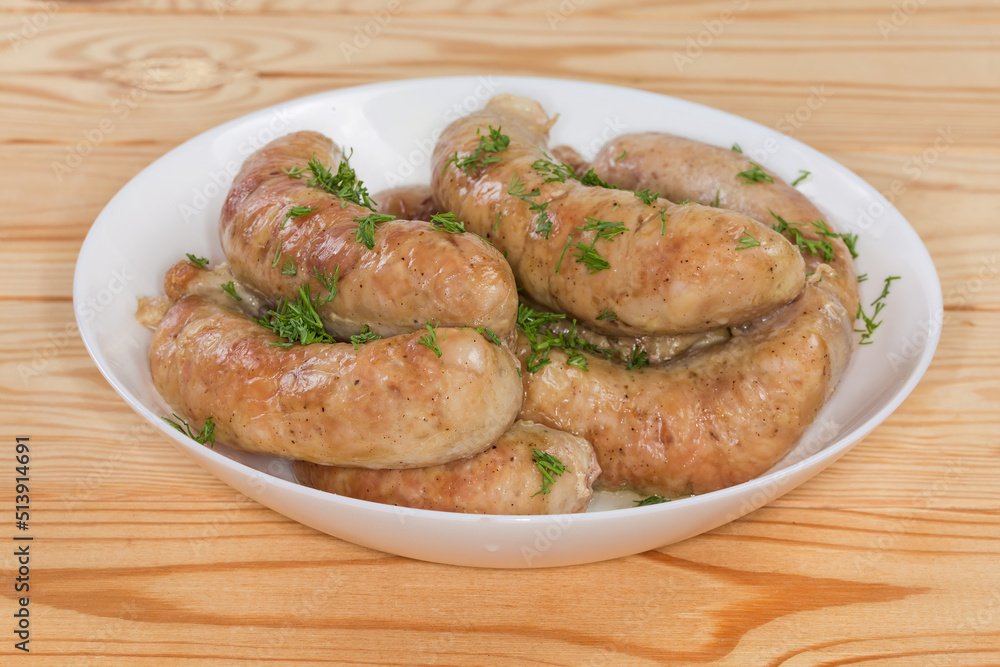 Baked chicken sausages in bowl, close-up in selective focus