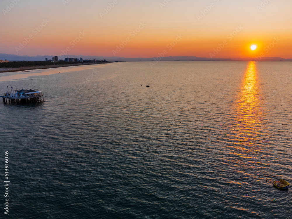 Naklejka premium Sunrise in Lignano Sabbiadoro seen from above. From the sea to the lagoon, the city of holidays