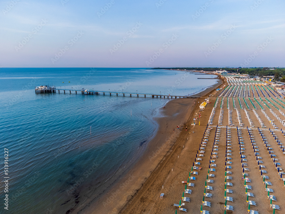 Fototapeta premium Sunrise in Lignano Sabbiadoro seen from above. From the sea to the lagoon, the city of holidays
