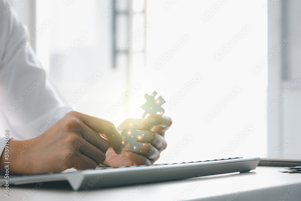 Obraz premium closeup woman hand holding jigsaw pieces on desk