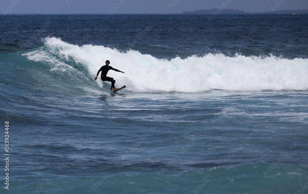 PUERTO DE SANTIAGO, TENERIFE - JUNE 2022: surfer riding the waves in Tenerife PUERTO DE SANTIAGO, TENERIFE - JUNE 2022: surfer riding the waves in Tenerife