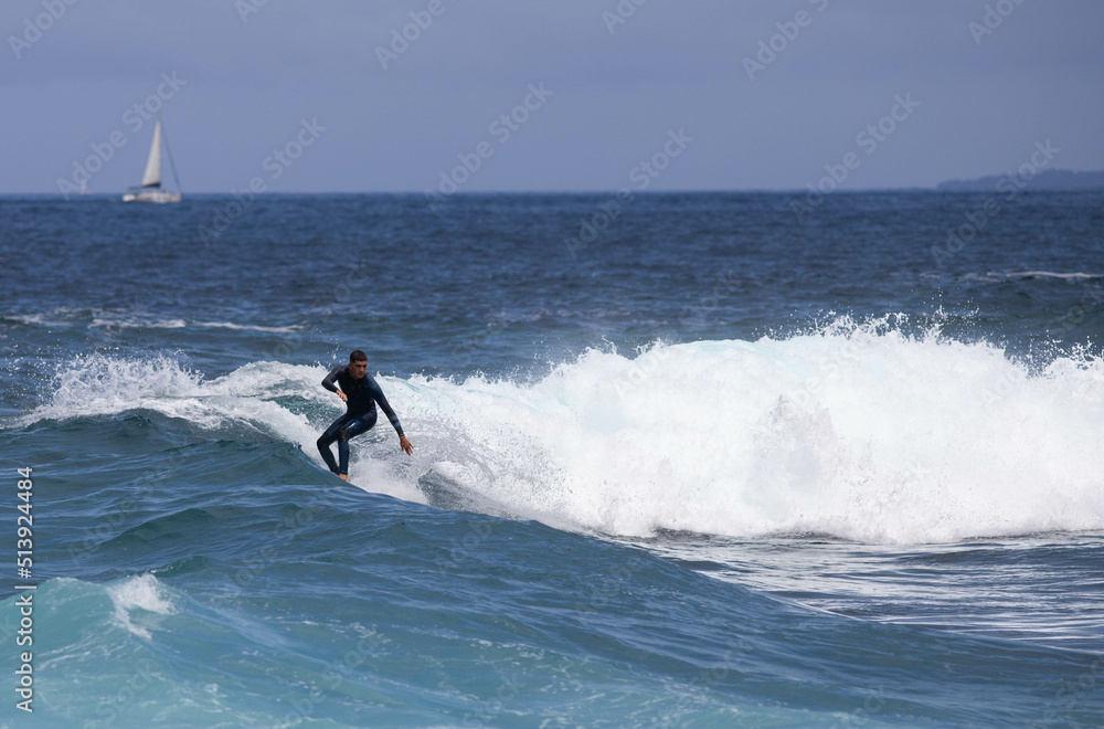 PUERTO DE SANTIAGO, TENERIFE - JUNE 2022: surfer riding the waves in Tenerife PUERTO DE SANTIAGO, TENERIFE - JUNE 2022: surfer riding the waves in Tenerife