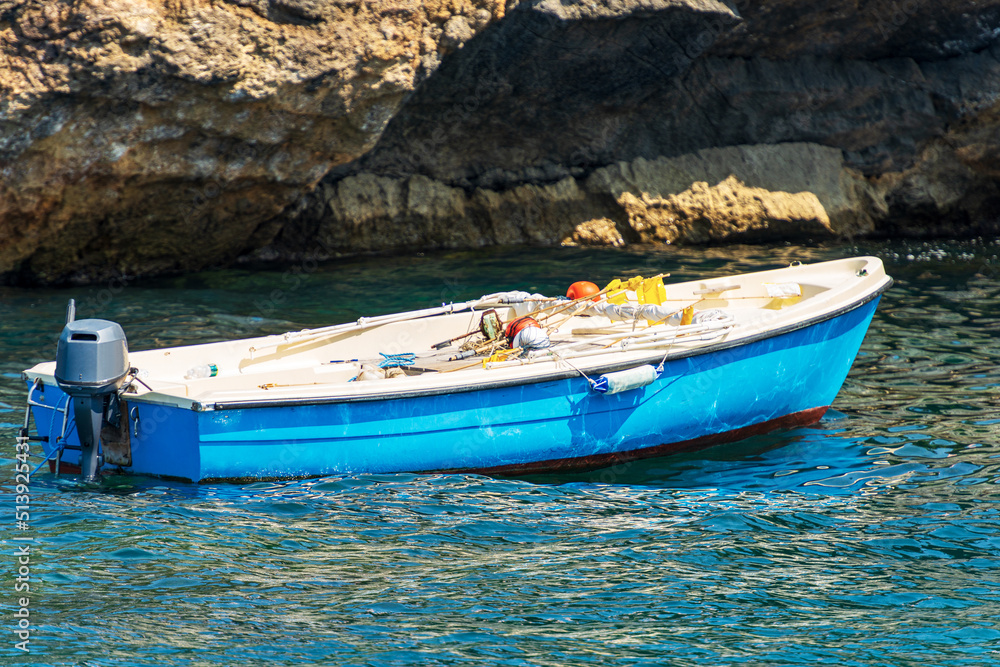 Fototapeta premium Closeup of a small motorboat used as a fishing boat with fishing equipment (buoys with flags for fishing with nets). Gulf of La Spezia, Italy, Europe.