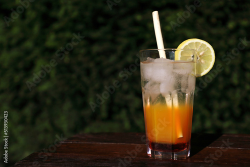 Coctail with lemon, ice and bamboo reed straw made of natural materials, without chemicals and plastics with dark background with space for text. Ecological, environmentally free.