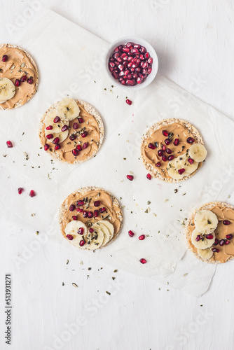 Rice crackers with peanut butter, banana and pomegranate