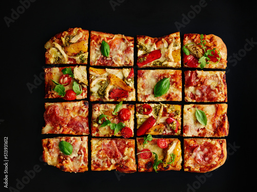 Colorful salami pizza baked in a tray, sliced