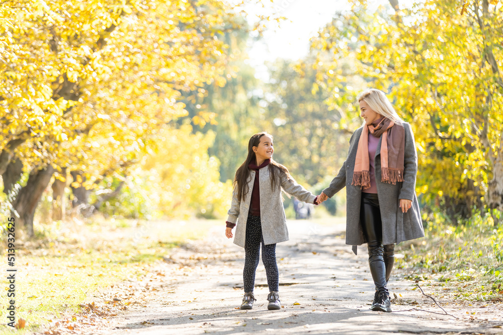 Obraz premium mother with her daughter in autumnal alley