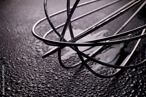 close-up metal whisk tool with water drops