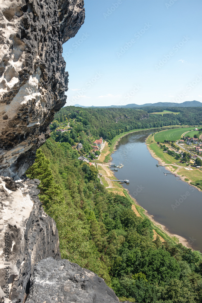 Cover page with birdview over monumental Bastei sandstone pillars near Kurort Rathen village in the national park Saxon Switzerland by Dresden and Elbe river with blue sky, Saxony, Germany.
