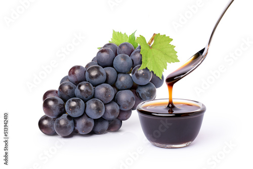 Photos Bunch of black grape with green leaf and grape molasses in glass bowl isolated on white background