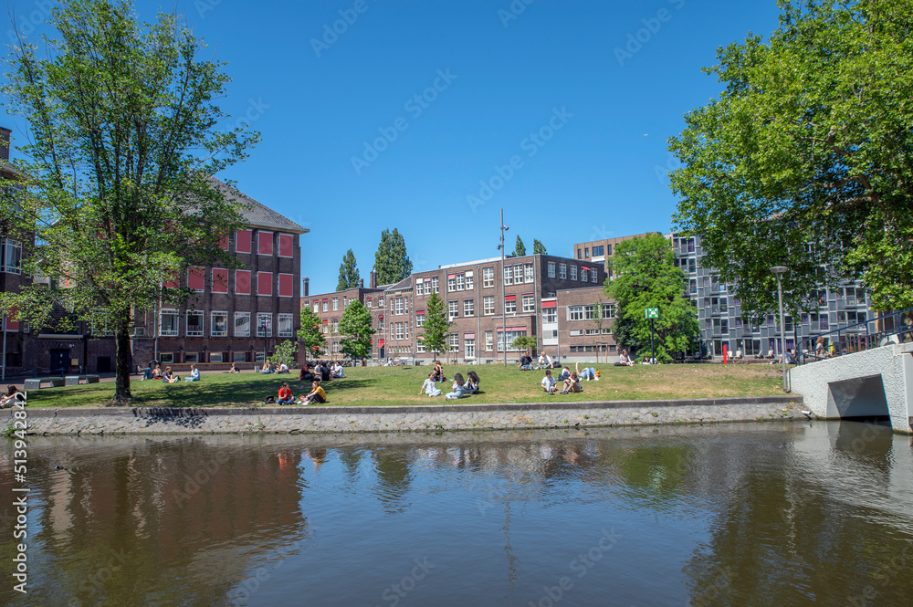 Fototapeta premium Student Enjoying The Sun At Nieuwe Achtergracht Canal At Amsterdam The Netherlands 22-6-2022