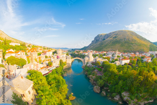 Fantastic Skyline of Mostar with the Mostar Bridge, houses and minarets, during sunny day. Location: Mostar, Old Town, Bosnia and Herzegovina, Europe photo