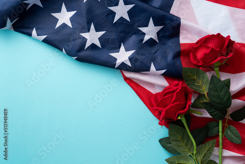 Fototapeta Naklejka Na Ścianę i Meble -  Concept of Independence day or Memorial day. American Flag over blue table background with red rose.