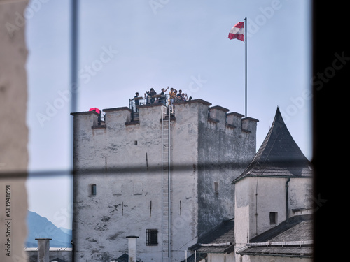 View from Hohensalzburg Fortress through a barred window to an outdoor tower full of tourists, Salzburg, Austria