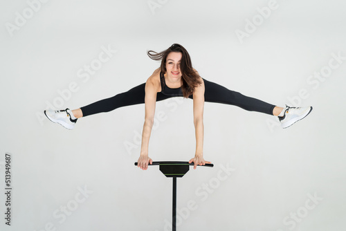 young fitness woman In sportswear jumping on sport trampoline White background photo