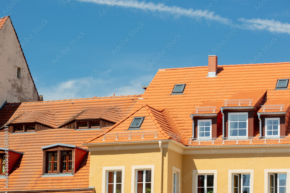 Old house with new tiles and blue sky on background