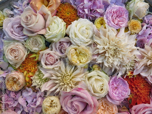 Floral background. Multi-coloured fresh pastel color flowers in the water  top view from above. Natural flat lay. Variety of flowers.