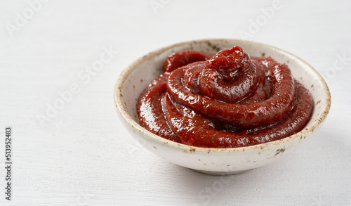 Obraz na plátně Gochujang or Korean red chili paste in a ceramic bowl on white wood background
