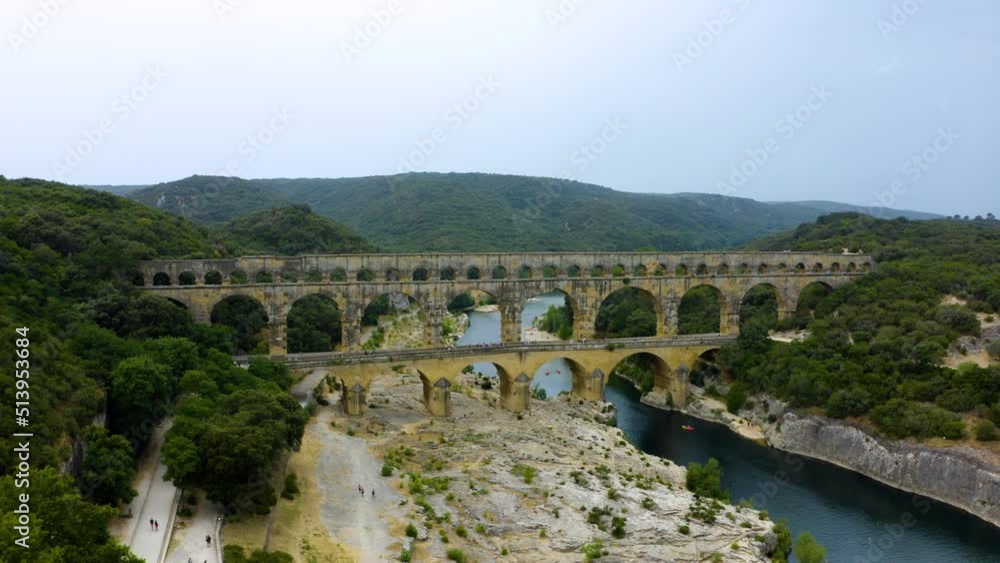 aerial of Pont du Gard is an ancient Roman aqueduct that crosses the Gardon River. The Pont du Gard is an ancient Roman aqueduct bridge built in the first century. aerial of Pont du Gard is an ancient Roman aqueduct that crosses the Gardon River. The Pont du Gard is an ancient Roman aqueduct bridge built in the first century.