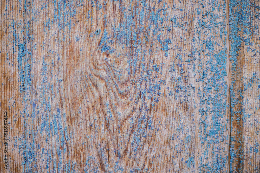 An old wooden door covered with old cracked blue paint. Uneven, rough surface. Rough texture. Abstract background. An old wooden door covered with old cracked blue paint. Uneven, rough surface. Rough texture. Abstract background.