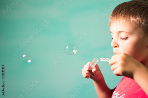 child blows soap bubbles