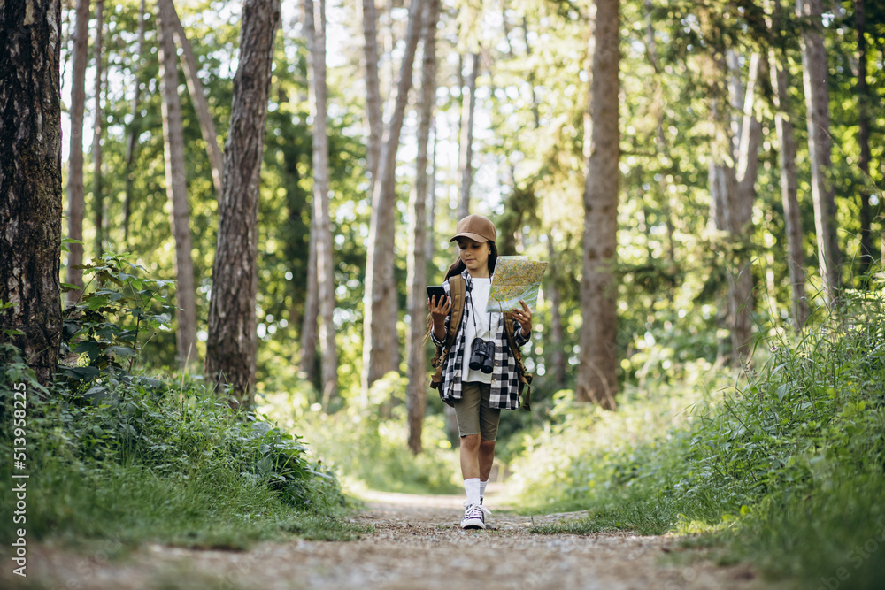 Obraz premium Girl scout looking on the map and phone in the woods