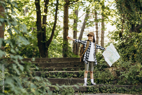 Girl looking at the map while walking in the forest