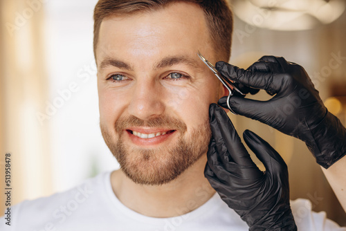Man at spa making treatment for his eyebrows
