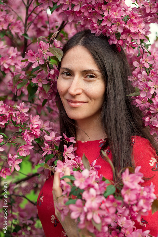 Portrait of a young woman in a blooming apple orchard. Portrait of a young woman in a blooming apple orchard.
