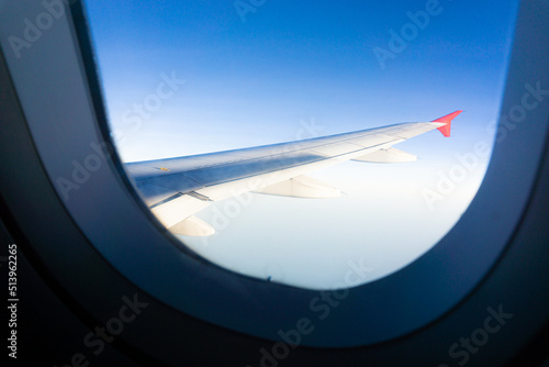 Airplane wing on blue sky cloud window view travel background