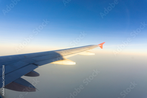 Airplane wing on blue sky cloud window view travel background