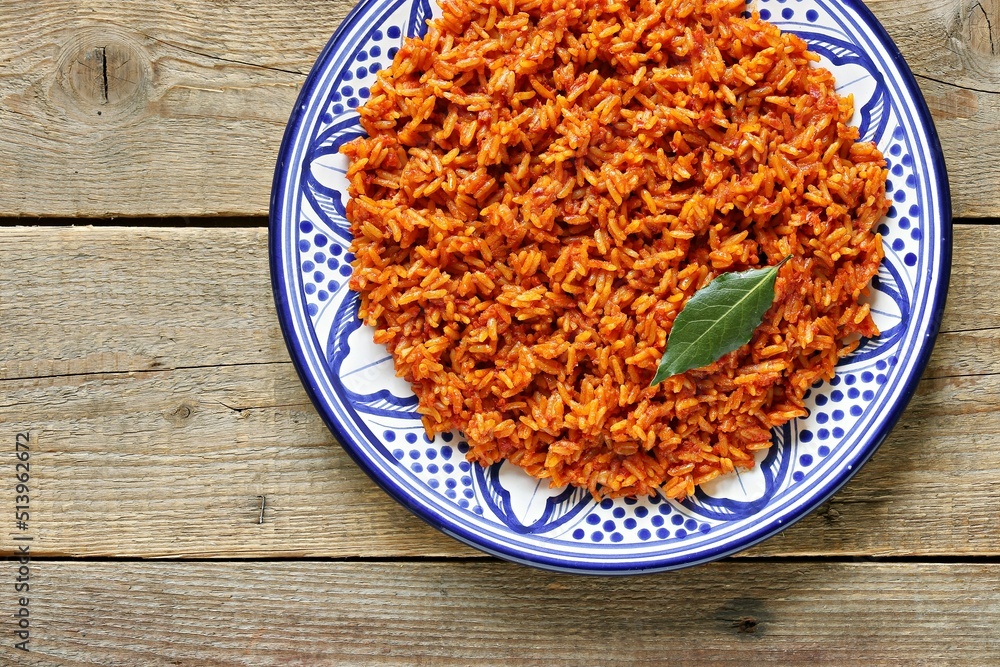 Jollof Rice. Traditional Nigerian spicy rice dish. National Jollof Rice day. Stock Photo Adobe