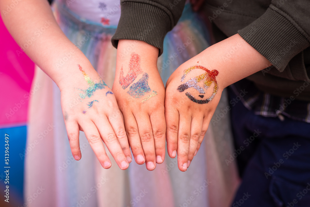 Shimmering sparkling glitter tattoos on children's hands at a birthday party