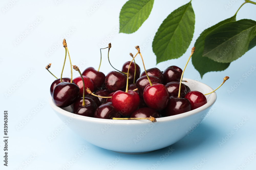 Juice and fresh cherry with leaf and water drops on blue background. Sweet red berry cherries. Summer fruit Background Juice and fresh cherry with leaf and water drops on blue background. Sweet red berry cherries. Summer fruit Background