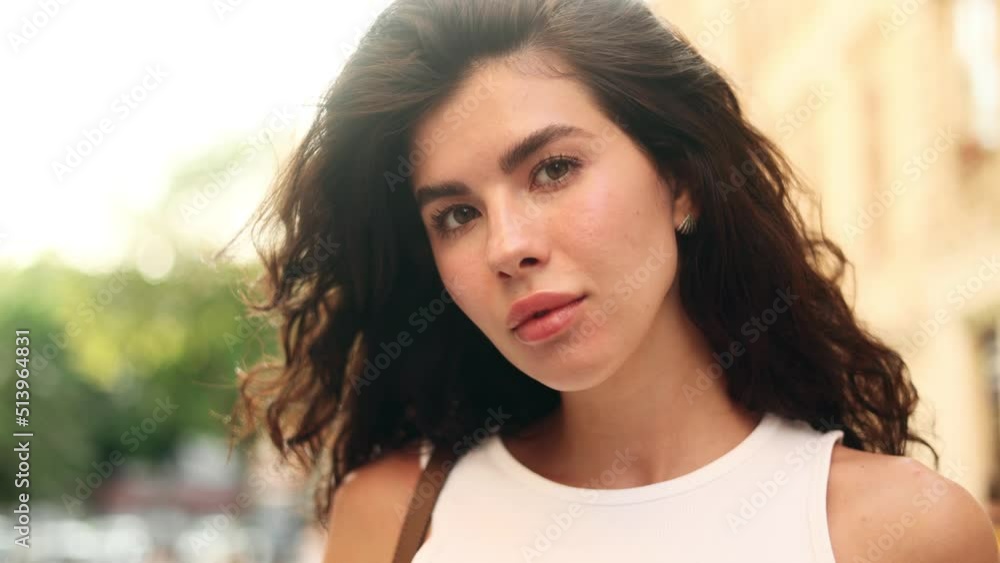 Serious portrait of stunning young brunette woman in the street and looking at the camera. Attractive woman in the city centre. Serious portrait of stunning young brunette woman in the street and looking at the camera. Attractive woman in the city centre.