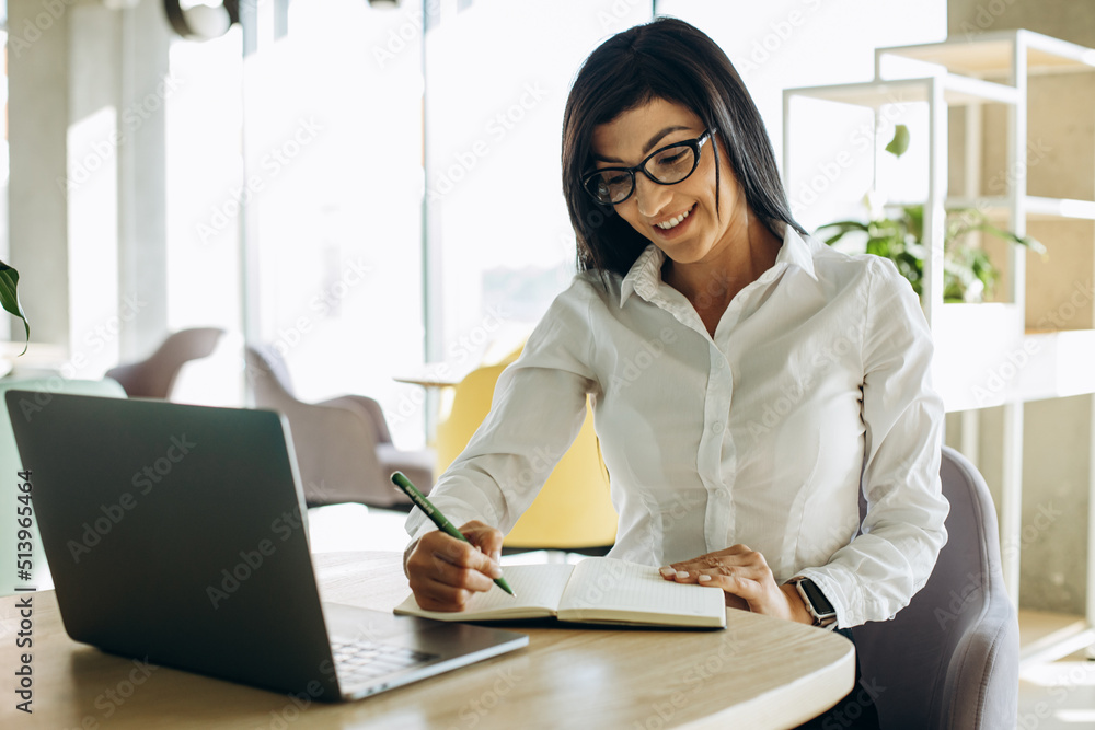 Young business woman working in office on computer and drinking coffee Young business woman working in office on computer and drinking coffee