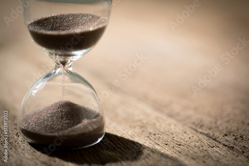 hourglass (sand clock) on an old wooden table, Hourglass as time passing concept for business deadline, elapsed time concept, copy space