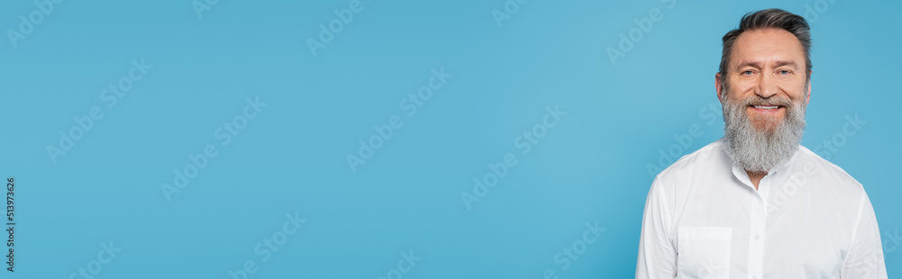bearded guru man in white shirt smiling at camera isolated on blue, banner. bearded guru man in white shirt smiling at camera isolated on blue, banner.