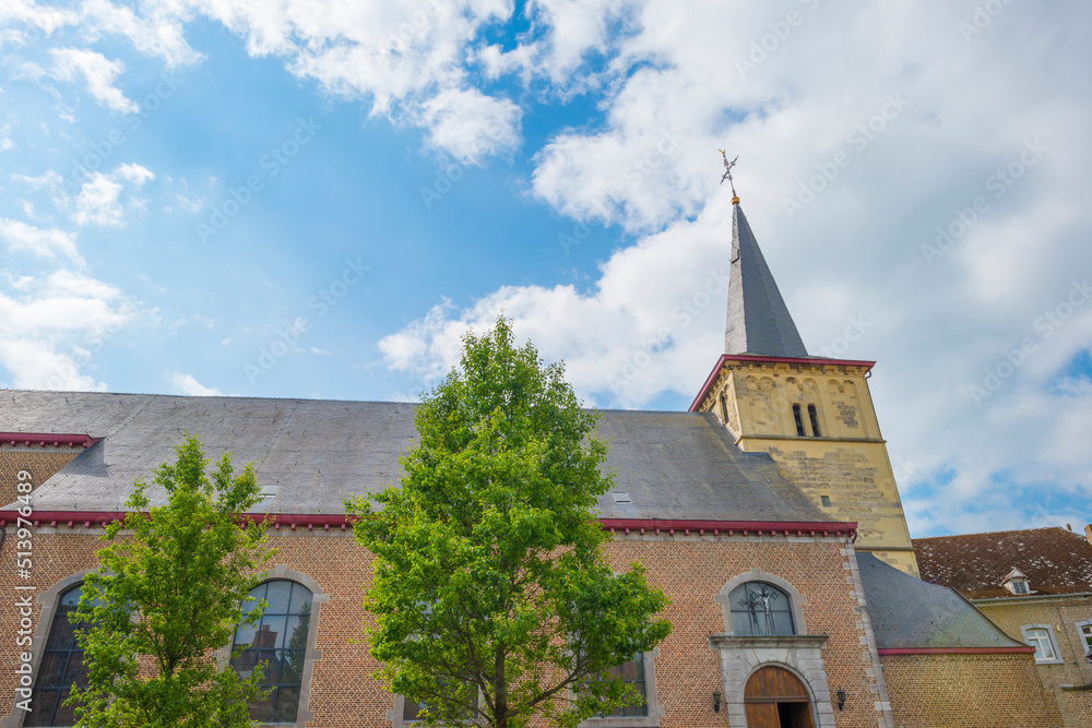 Tower of an ancient church in bright sunlight in a blue sky in springtime, Voeren, Limburg, Belgium, June, 2022