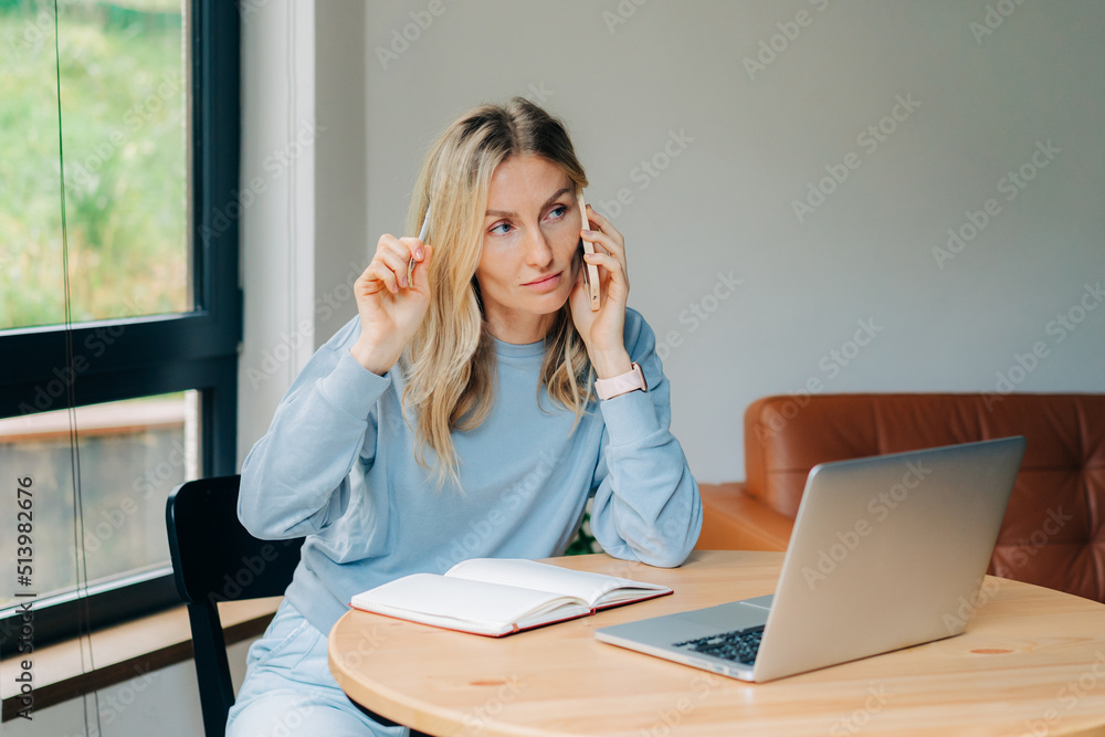 Businesswoman talking on the phone while working at home. Businesswoman talking on the phone while working at home.