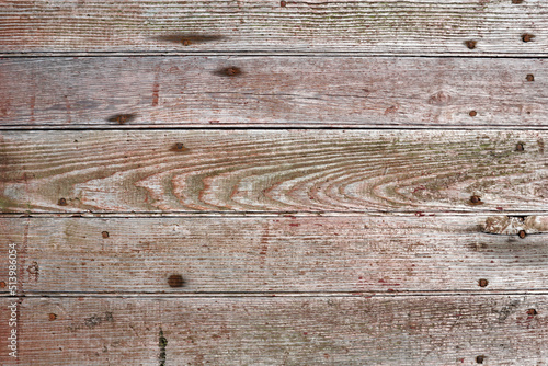 Closeup of weathered red boards arranged in a horizontal pattern