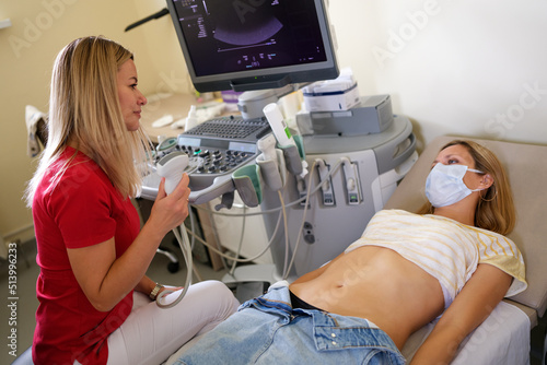 Doctor examines woman with ultrasound scanner closeup