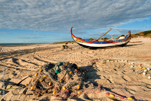 nets and colorful fishing boats on the sand, along the Atlantic, on the beach of Torreira, Portugal photo