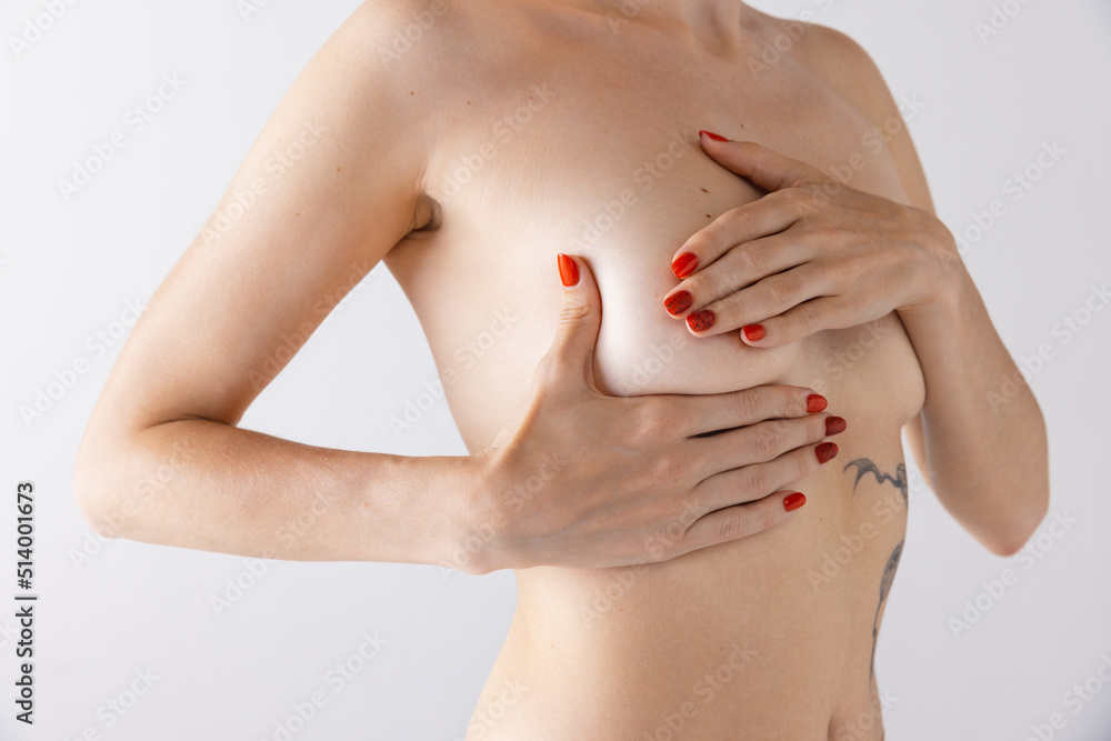 Fototapeta premium Cropped image of female body, breast isolated over grey studio background. Plastic surgery, mammoplasty, female health.