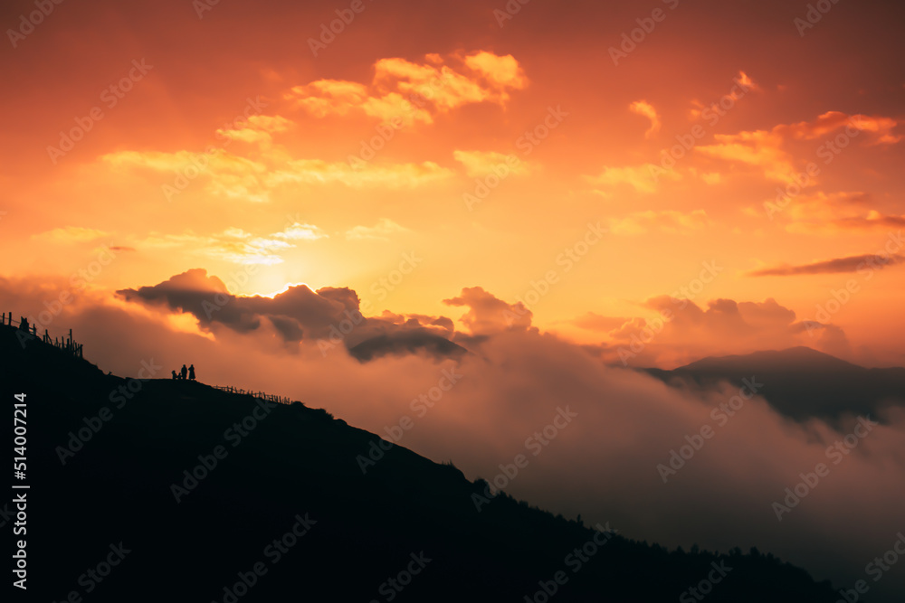 Obraz premium Beautiful sunset over the silhouette of the mountain with clouds. Dramatic sky cloudscape